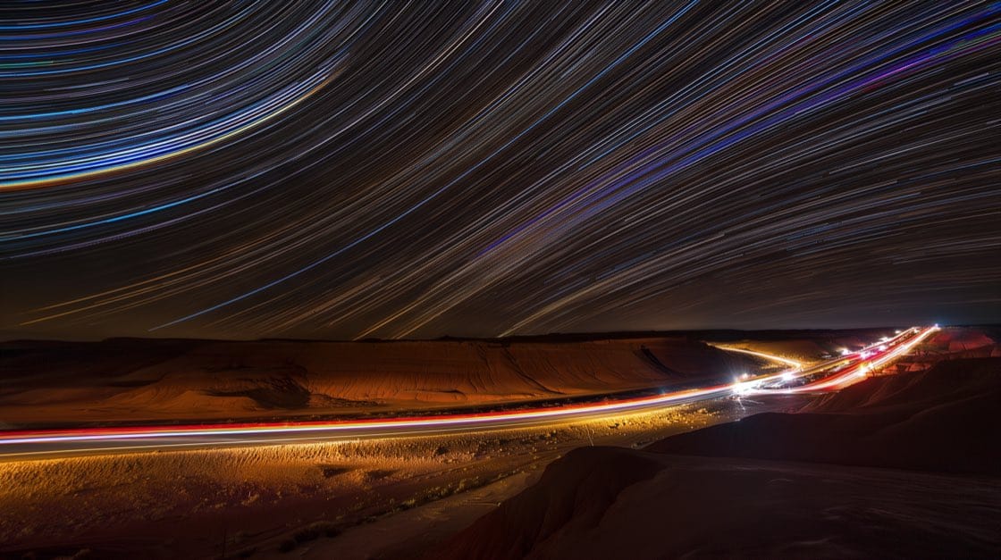 Star trails over a desert highway